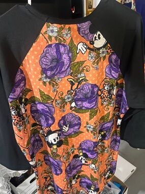 This is a LuLaRoe Minnie Mouse floral Randy tee featuring black raglan sleeves.